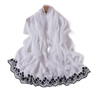 Delicate white chiffon scarf detail featuring exquisite black floral embroidery along the border.