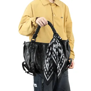 Détail du sac cabas en cuir noir gaufré de têtes de mort avec foulard style punk.