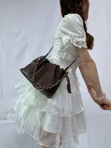 Vue détaillée du sac porté épaule marron style nuage avec chaîne et lien de serrage.