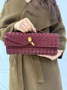Burgundy woven leather clutch bag featuring unique metal knot and stylish evening design.