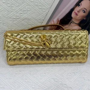Golden metallic woven clutch bag with elegant knot design, perfect for evening parties and events.