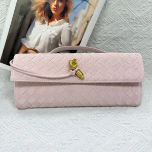 Pink woven leather clutch bag with elegant metal knot closure and vintage baguette design for evening.