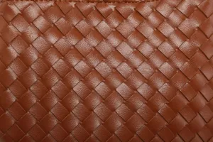 Close-up van de premium bruine geweven lederen textuur met fijne ambachtelijke details.