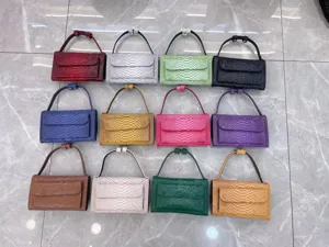 Detailed view of colorful embossed leather baguette underarm bags arranged in a neat grid display.