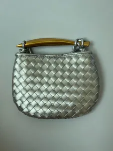 Mini geweven lederen handtas met gouden metalen handvat zilveren schoudertas stijlvol chic.