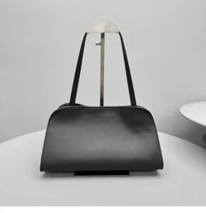 Λεπτομερης εικονη της κομψης μαυρης δερματινης τσαντας ωμου με προσεγμενο φινιρισμα.