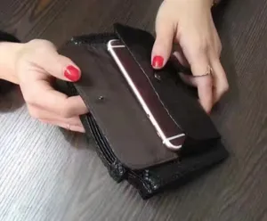 Black textured leather clutch wallet showcasing interior card slots and phone compartment detail view