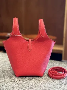 Detailed shot of red litchi leather bucket handbag, showing exquisite stitching and texture.