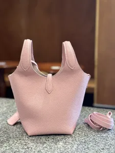 Pink genuine leather bucket bag, soft pebbled texture, top handle handbag with adjustable strap.