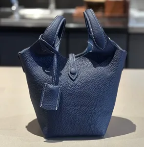 Classic blue leather bucket bag top grain cowhide tote handbag with twin handles and strap.