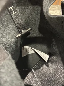 Interior detail of genuine leather bucket bag showing soft pebble leather and metal lock structure.