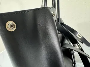 Premium black leather tote bag with metal snap buttons, stylish commuter handbag for women.