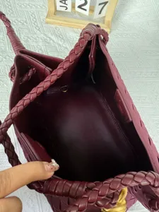 Detailed view of the burgundy woven leather handbag interior and artisanal strap texture.