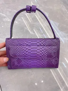 Purple python texture baguette underarm shoulder bag featuring top handle and elegant flap closure.