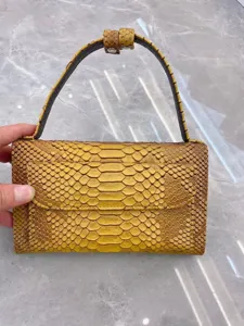 Close-up detail of the mini baguette shoulder bag with exotic python texture and front flap.