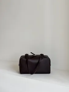 Dark brown leather bowling bag detail, minimalist Boston bag with top zip and handles.