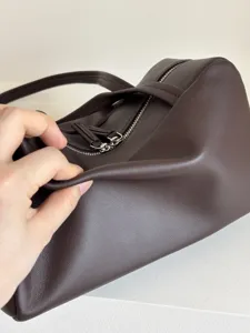 Dark brown leather boston bag detail showing soft lambskin texture, premium metal double zippers.
