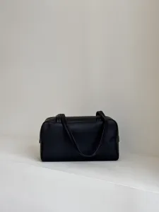 Detail view of the black leather boston bag, featuring smooth leather and sturdy double handles.