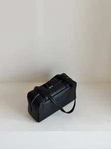 Black lambskin boston bag detail showcasing the premium leather texture and silver zipper.