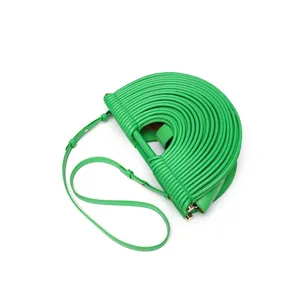 Sac à main demi-lune en cuir vert avec design découpé en U unique et bandoulière réglable.