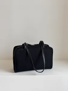 Detailed view of black canvas boston bag with dual handles and zip closure for daily use.
