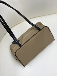 Detailed view of the stylish khaki boston bag featuring black leather trim and double straps.