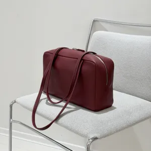Burgundy leather shoulder bag for women, minimalist bowling bag with spacious design for daily use.
