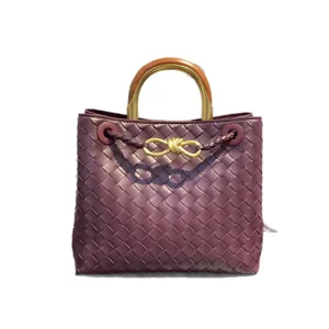 Burgundy woven leather tote bag with metal wooden handle and gold knot design for women