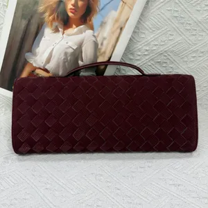Burgundy woven clutch bag detail shot, vintage long evening bag with top handle design.