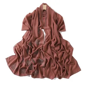 Detailed view of rhinestone chiffon hijab scarf with decorative spiral rose patterns, elegant.