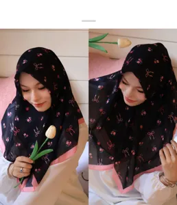 Gros plan du foulard en mousseline noir à motifs de fleurs et nœuds, doux et élégant.