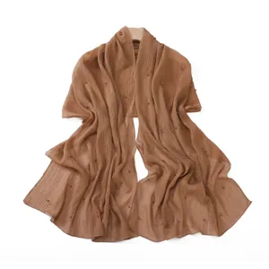 Detailed view of brown pleated chiffon scarf with pearls and silver thread, elegant shawl detail.