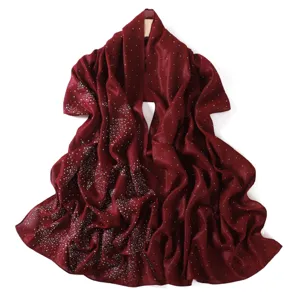 Close-up detail of wine red sparkling rhinestone chiffon scarf with starry pattern texture.
