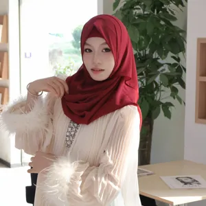 Detailed view of elegant Muslim hijab and pleated top set worn by model, beautiful indoor scene.