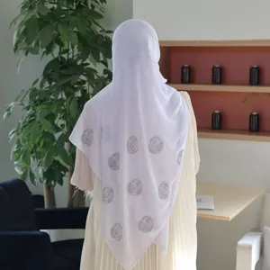 Nahaufnahme Detailansicht des weißen Chiffon Hijabs mit eleganten Strassrosenmustern.