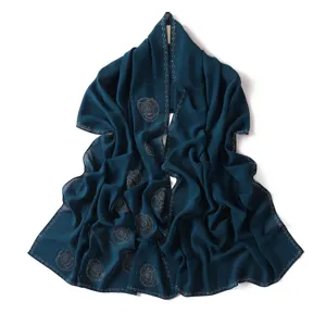 Dark blue chiffon hijab scarf with elegant rhinestone spiral patterns and sparkly edges.