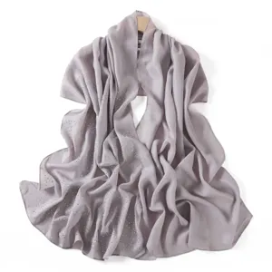 Close up detail of sparkling rhinestone chiffon scarf shawl, shimmering silver fabric texture.