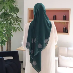 Detailansicht des dunkelgrünen Chiffon-Hijabs mit funkelnden Strass-Rosenmustern, eleganter Stil.