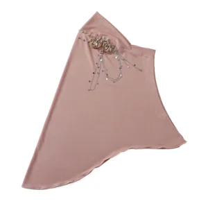 Close-up detail of the elegant pink headscarf featuring delicate hanging star chains.