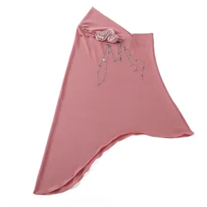 Detailed view of the pink pullover headscarf featuring star metal tassels and floral brooch.