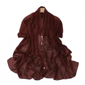 Detailed view of the dark red pleated chiffon shawl featuring pearls and silver threads.