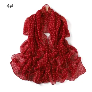 Dettaglio in primo piano della sciarpa rossa in cotone lino con stampa a cuori.