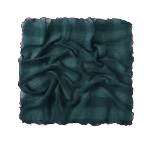 Detailed view of dark green crinkled square scarf with stylish wine-red lettuce edge.