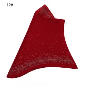 Close-up detail of red rhinestone studded Muslim hijab headscarf, soft threaded fabric.