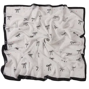 Chiffon square scarf detail, black and white bow print, elegant neckerchief texture.