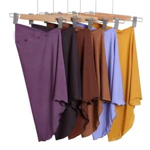 Dettaglio di diversi hijab elasticizzati a tinta unita appesi ordinatamente su grucce.