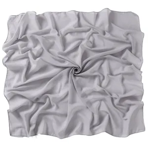 Detailed view of the light grey chiffon square hijab fabric texture, elegant solid color.