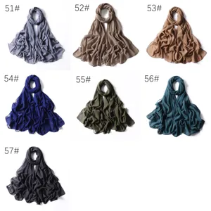 Dettagli in primo piano di lunghe sciarpe in chiffon scintillante tinta unita con tocchi dorati.