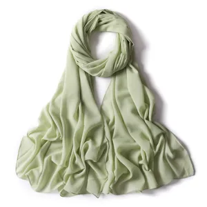 Dettaglio della sciarpa hijab in chiffon verde salvia con sottile luccichio dorato, leggera.