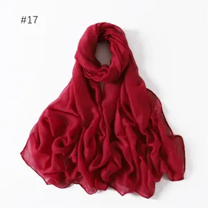 Detail shot of a lightweight solid red polyester long scarf, perfect for travel and daily wear.